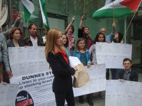 Click on image to see full-sized version Freda Hughes IPSC Chairperson holding 6,000 signatures calling on Dunnes to stop stocking Israeli produce